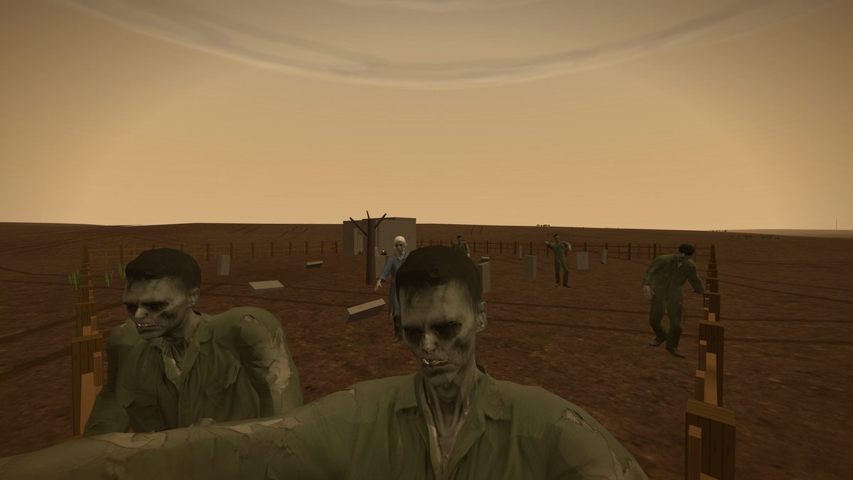 Two zombies in torn olive coveralls close on the camera across a bare-earth graveyard. The nearer one fills the bottom of the frame, head tilted, jaw slack, arms spread wide; the second stands just behind him at the left, stooped over a low wooden fence. Behind them a woman in a pale blue smock and white headscarf and three more figures come on past leaning concrete grave markers and a dead tree, under a flat amber sky.